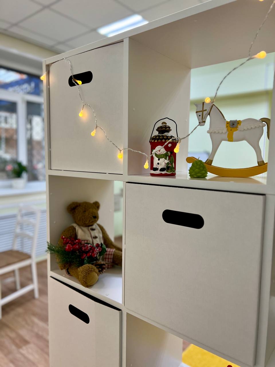 Полки с развивающими игрушками и тёплой гирляндой